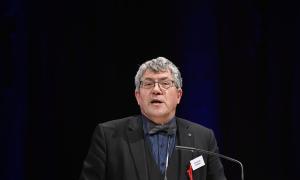 Ein Mann mit Brille und Fliege im schwarzen Anzug