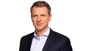 Ein Mann im Anzug schaut in die Kamera