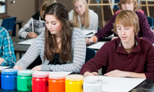 Jugendliche an einem Tisch mit Regenbogenfarben