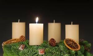 Ein Adventskranz, an dem eine von vier Kerzen brennt