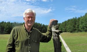 Ein Mann mit weißen Haaren und roter Brille