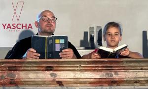 Ein Pfarrer und ein Junge sitzen auf einer Kirchenbank