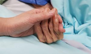 Eine Hand hält eine faltige Hand