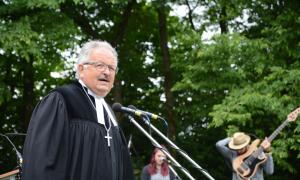 Ein Mann im Talar mit Kreuz um den Hals