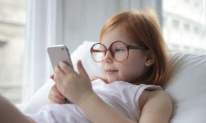 Ein Kind hält ein Smartphone und schaut auf den Bildschirm