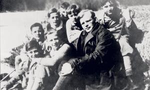 Dietrich Bonhoeffer mit Konfirmanden auf einer Wiese sitzend
