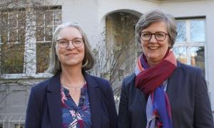 Zwei Frauen stehen vor einem Gebäude