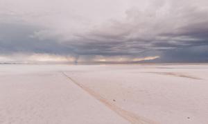 Eine Sandwüste, am Himmel Wolken