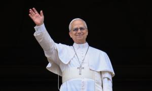 Ein Mann in weißem Gewand, um den Hals ein großes silbernes Kreuz
