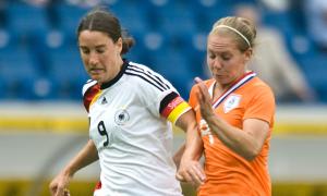 Zwei Frauen in Fußball-Trikots im Zweikampf
