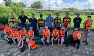Väter und Kinder mit Rettungswesten und Kanus