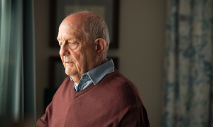 Ein älterer Mann schaut nachdenklich und gedankenversunken nach vorne