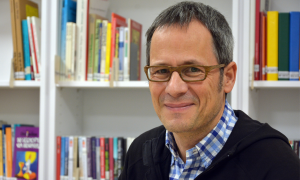 Roland Thürmel vor einem Bücherregal