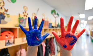 Bemalte Kinderhände rot und blau im Kindergarten