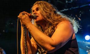 Ein Mann mit langen Haaren am Mikrofon