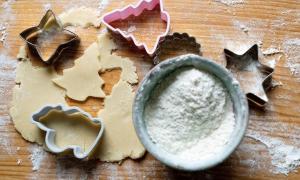Ausstecher, Butterplätzchen und Mehl auf einem Tisch