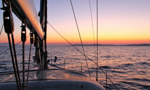 Im Abendlicht ein Boot auf dem weiten Meer ganz allein