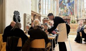 Menschen sitzen an Tischen in einer Kirche