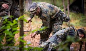 Männer in Uniformen kriechen im Wald herum