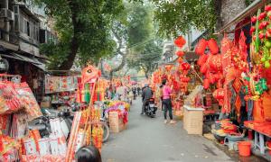 rechts und links an den Straßenrändern stehen Stände die rote Lampions und andere chinesische Dekorationen ausstellen