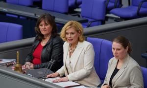 Drei Frauen sitzen an einem Pult