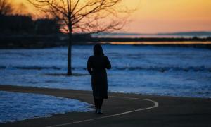 Eine Person steht auf einem Weg, im Abendlicht