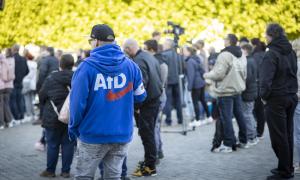 Ein Mann mit einer blauen Jacke, auf die das AfD-Logo gedruckt ist