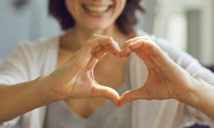 Frau zeigt Herz mit Hand