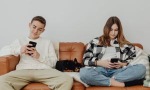 Zwei Junge Menschen auf Sofa mit Smartphone