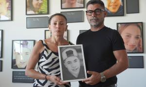 Eine Frau und ein Mann halten ein Foto eines Jungen