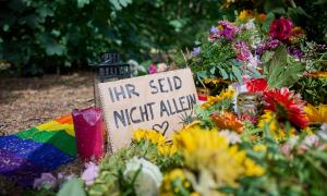 Blumen und ein Schild, auf dem "Ihr seid nicht allein" steht